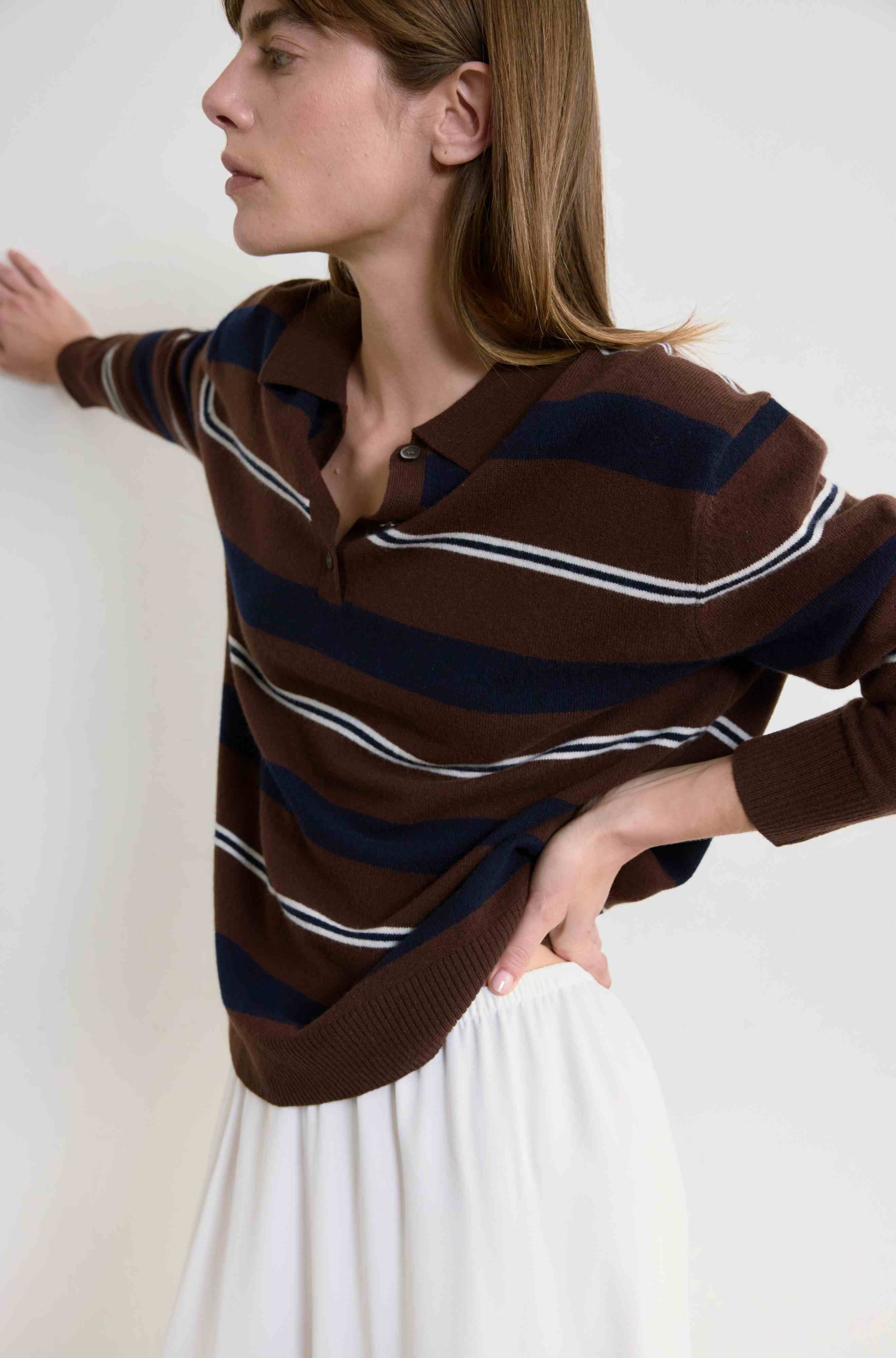Woman wearing a brown striped sweater against a white background