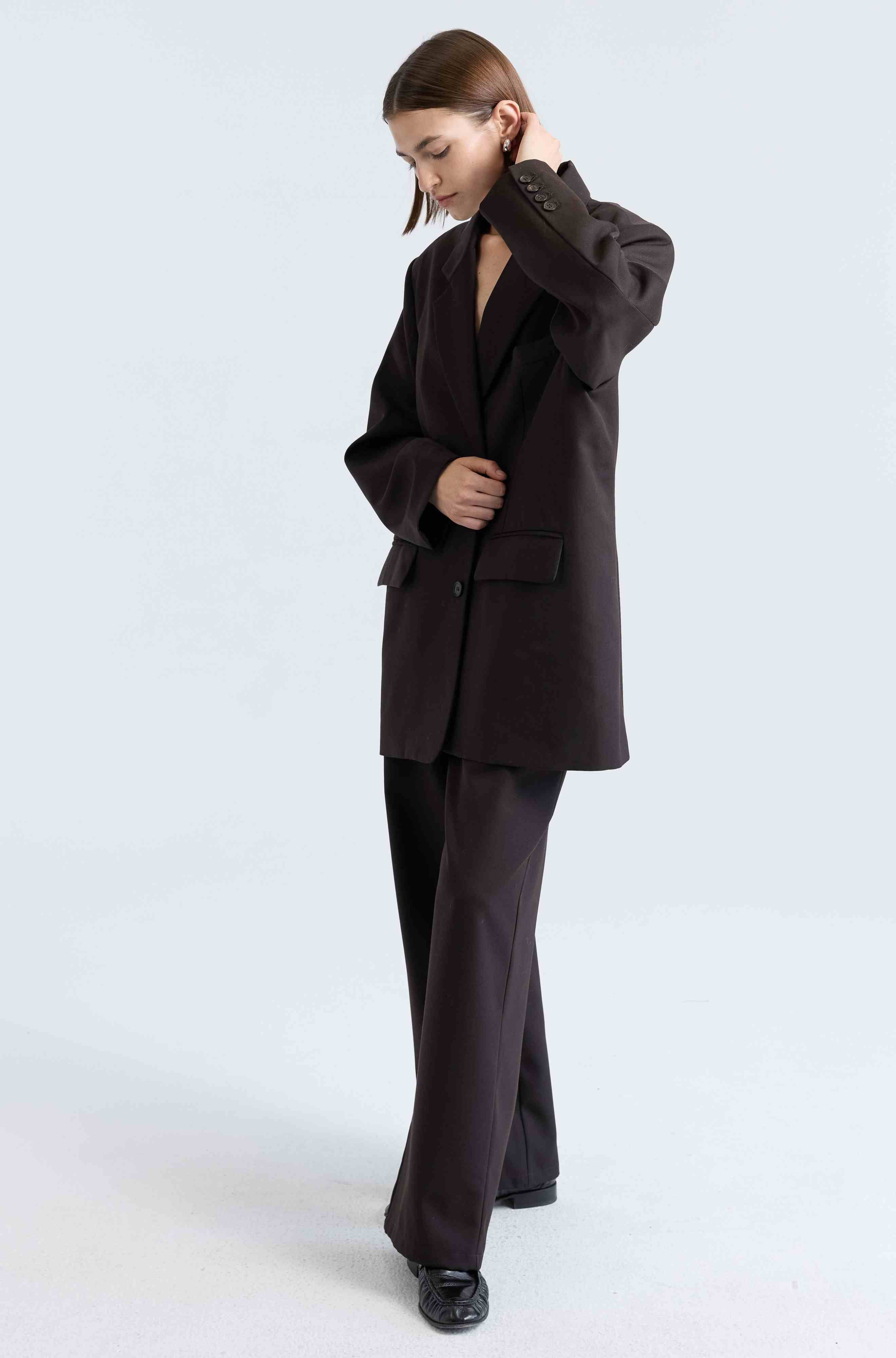 Person wearing a dark brown suit on a white background