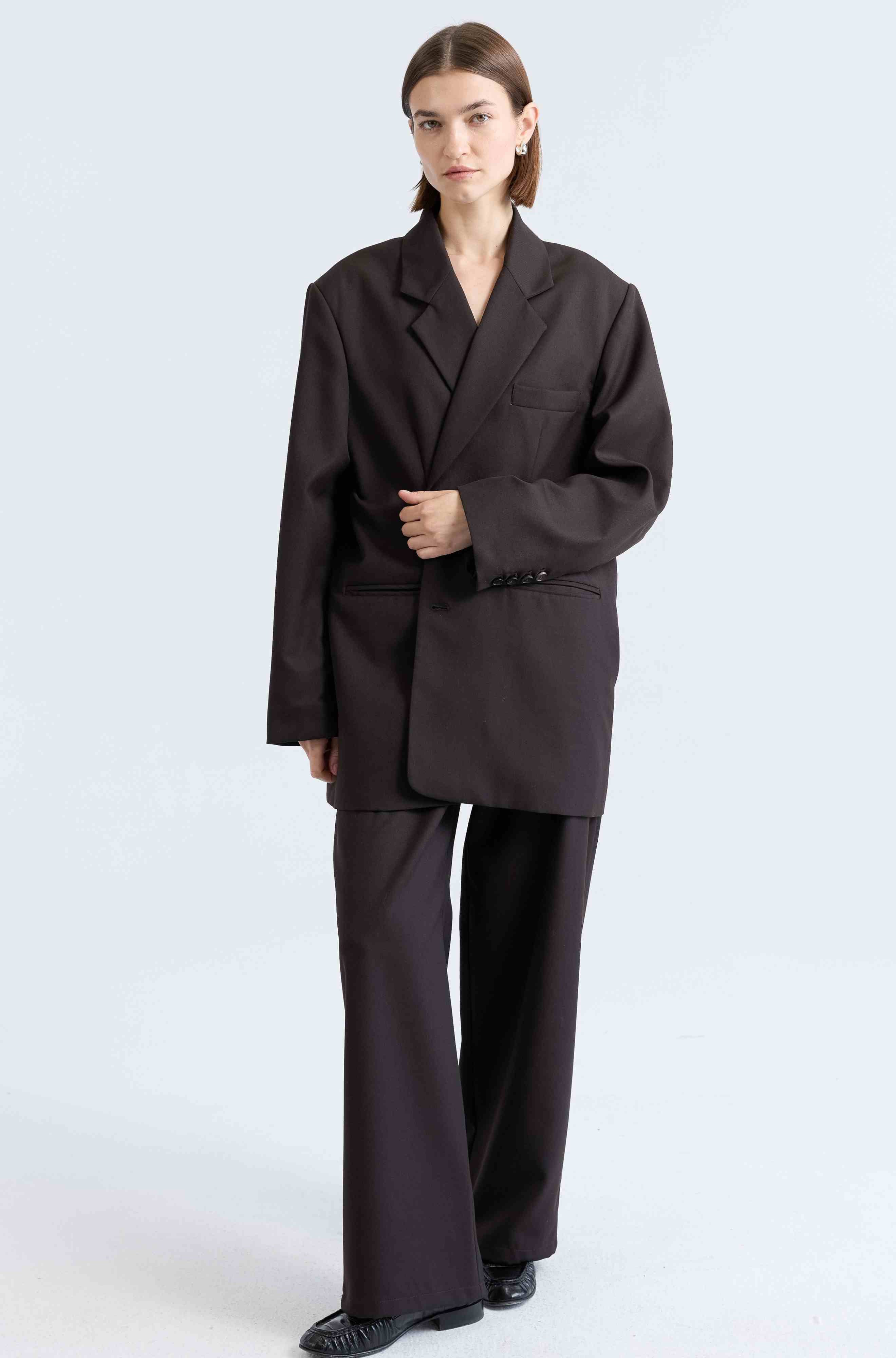 Person wearing a dark brown suit on a white background