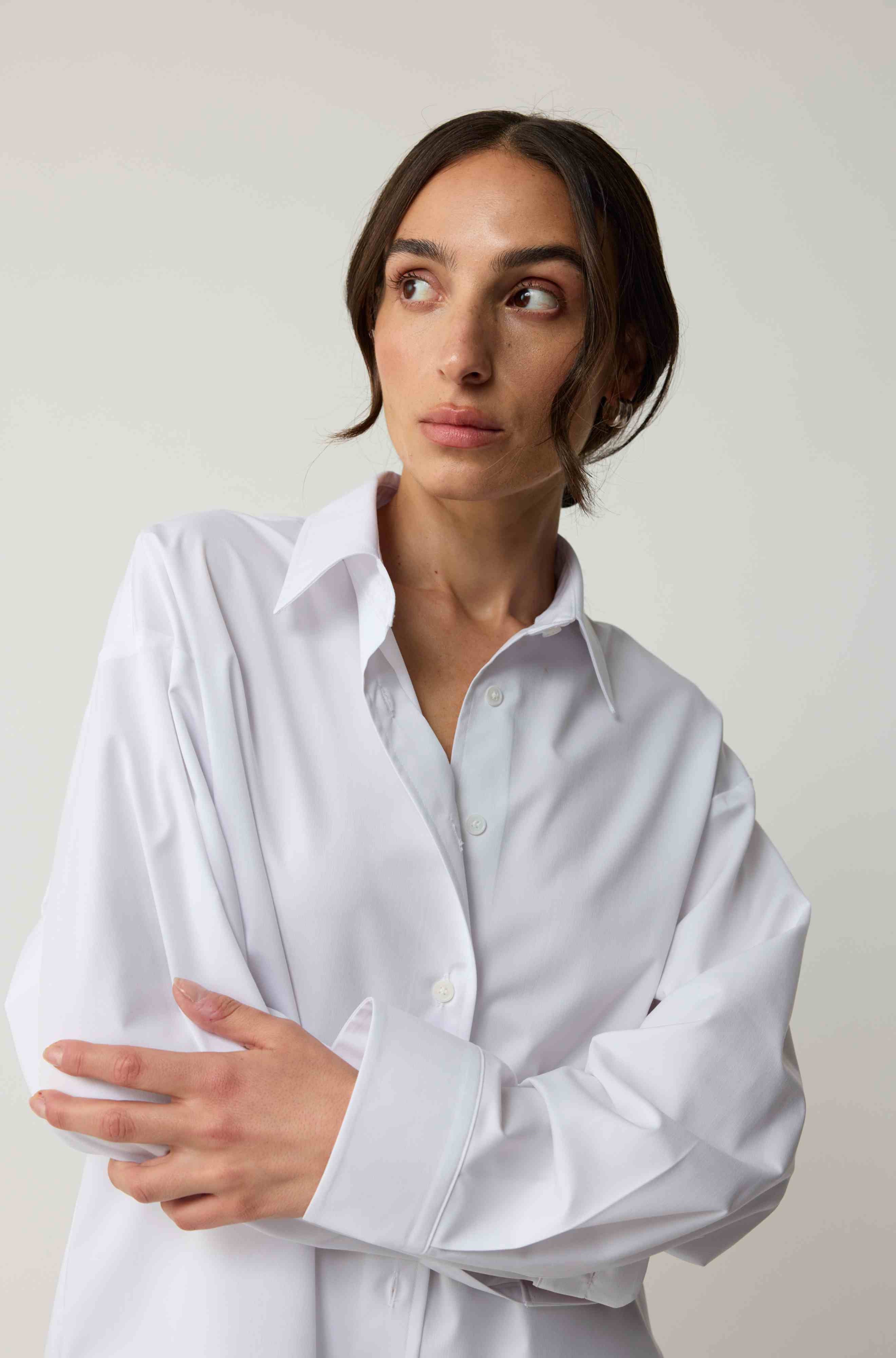 Woman wearing a white shirt against a plain background