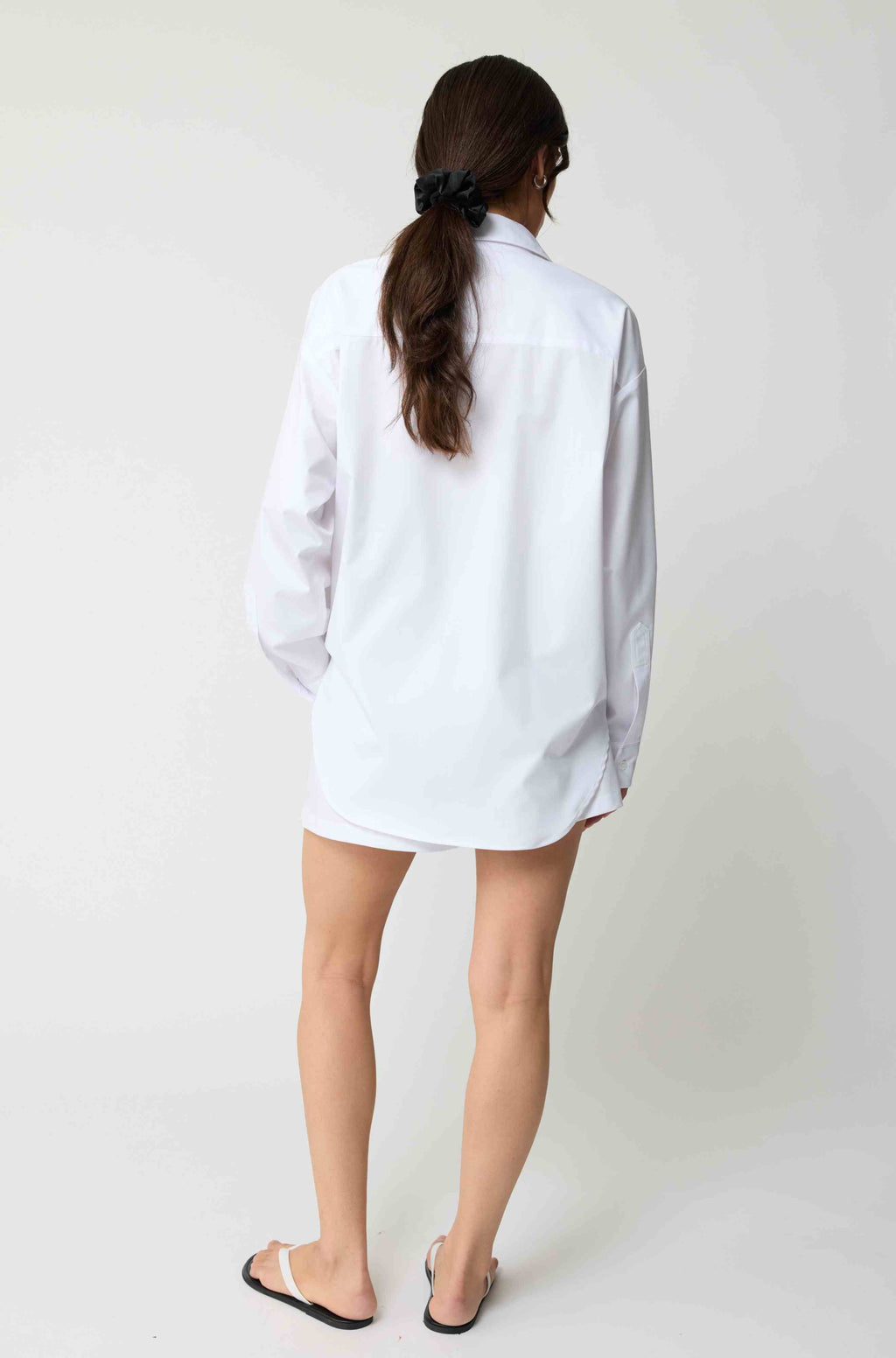 Person wearing a white shirt against a plain background