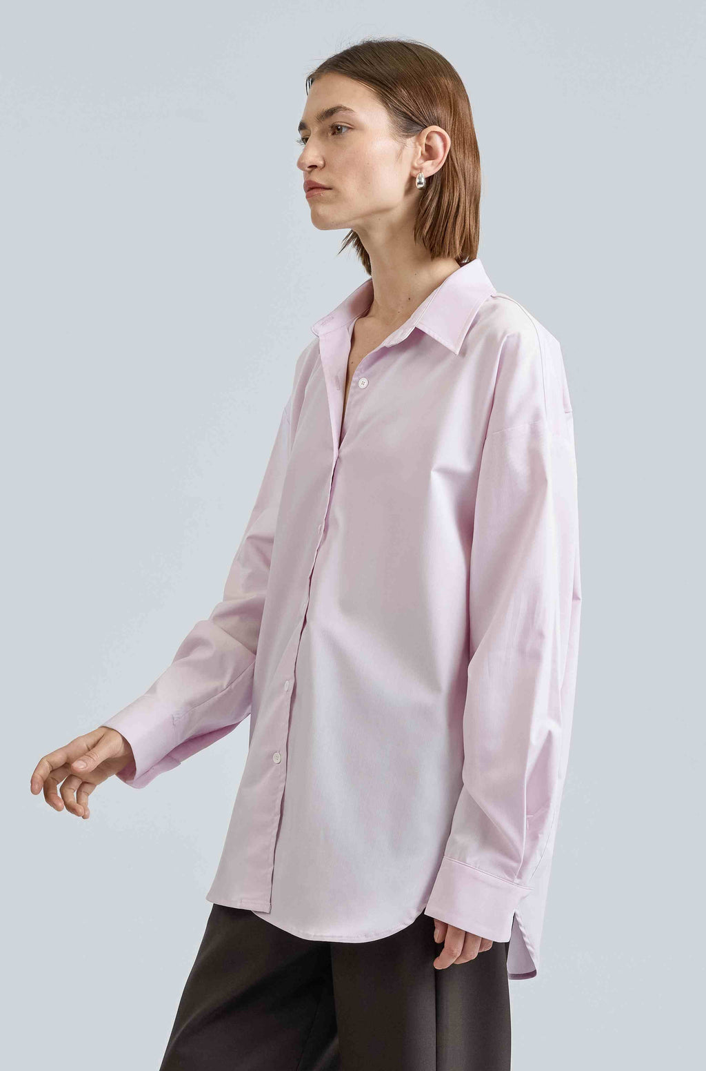 Woman wearing a light pink shirt against a plain background