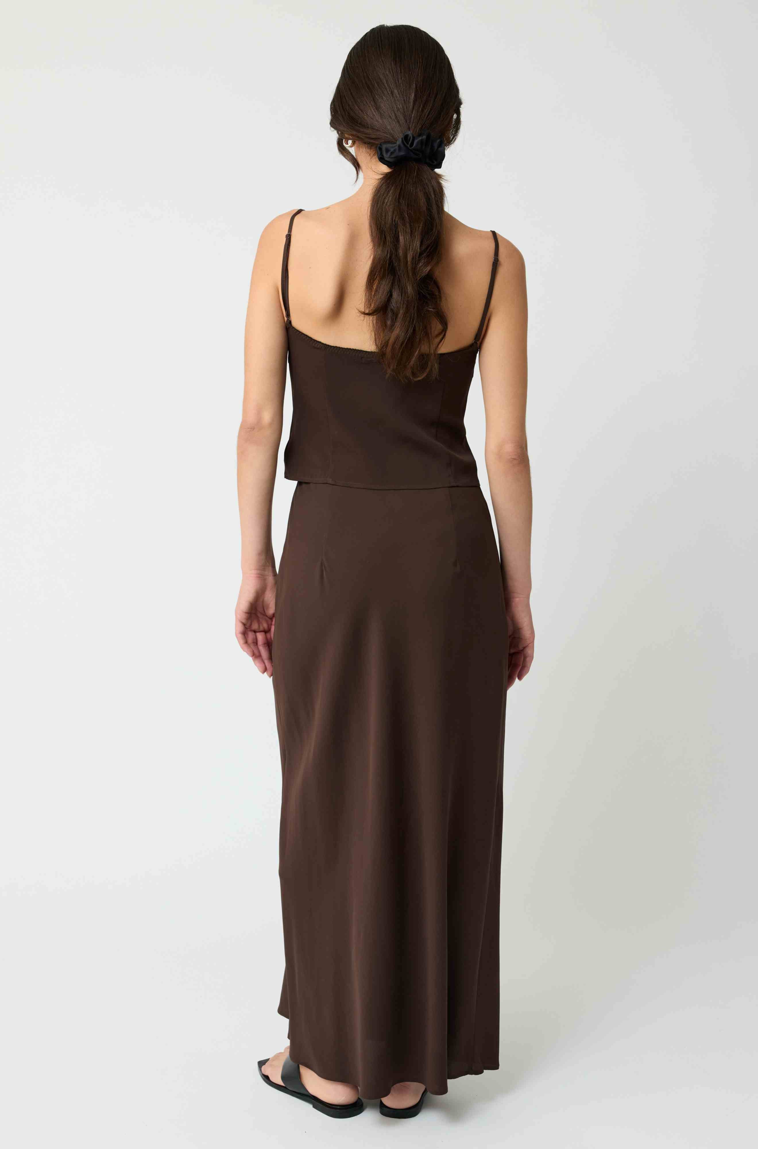 Woman wearing a brown dress with a plain white background