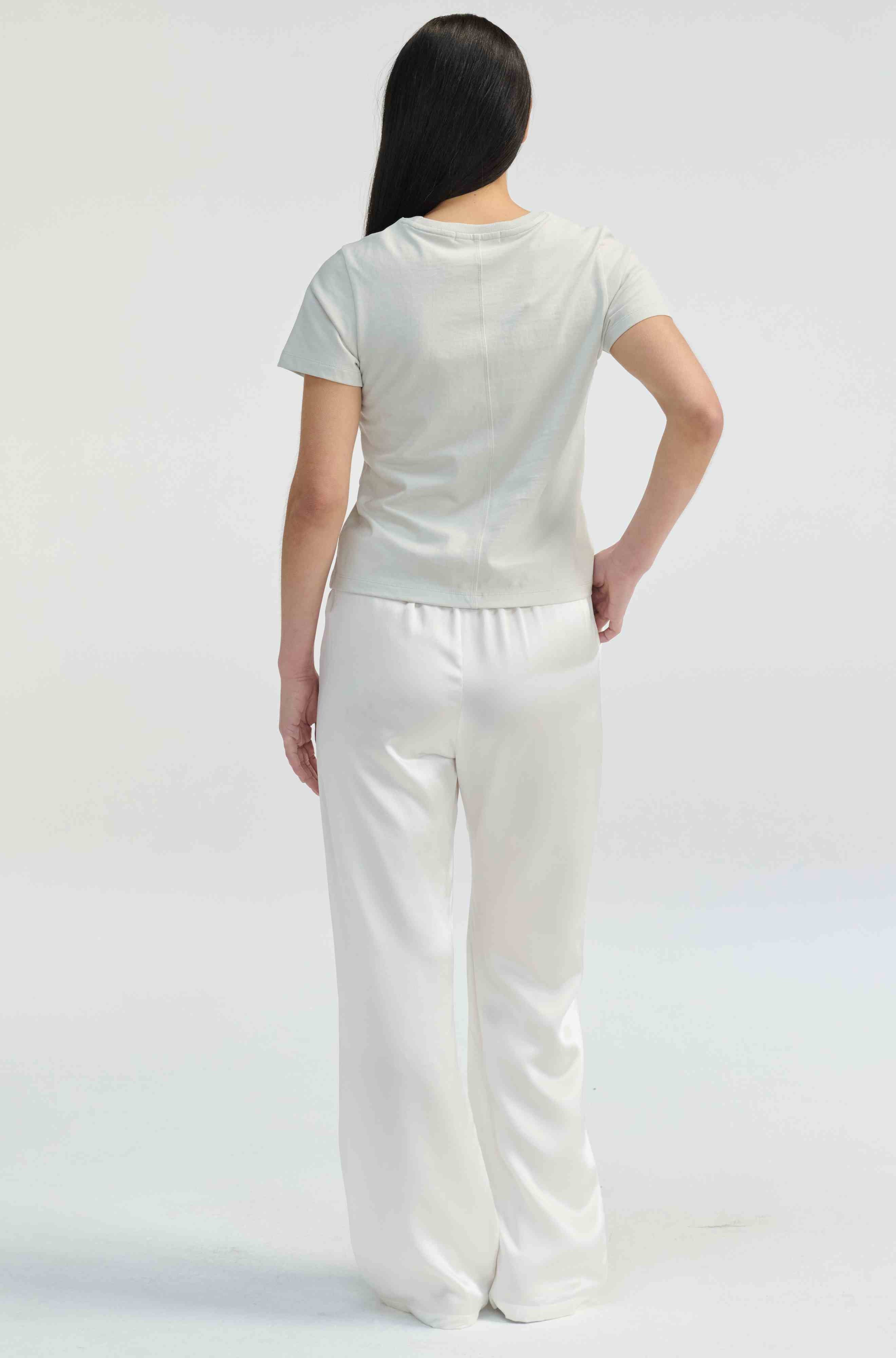 Person wearing a white outfit on a light gray background