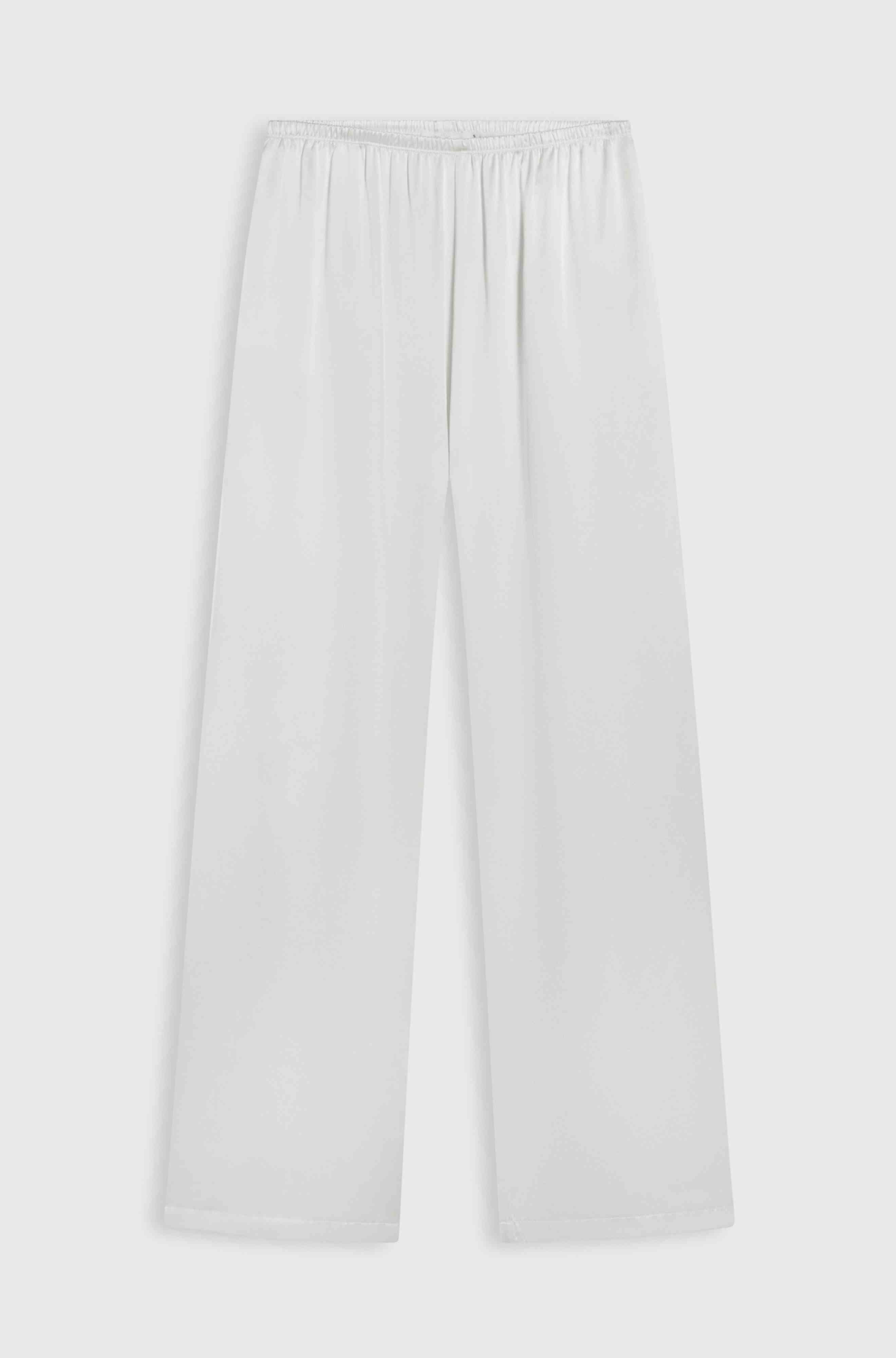 White wide-leg silk pants on a light gray background