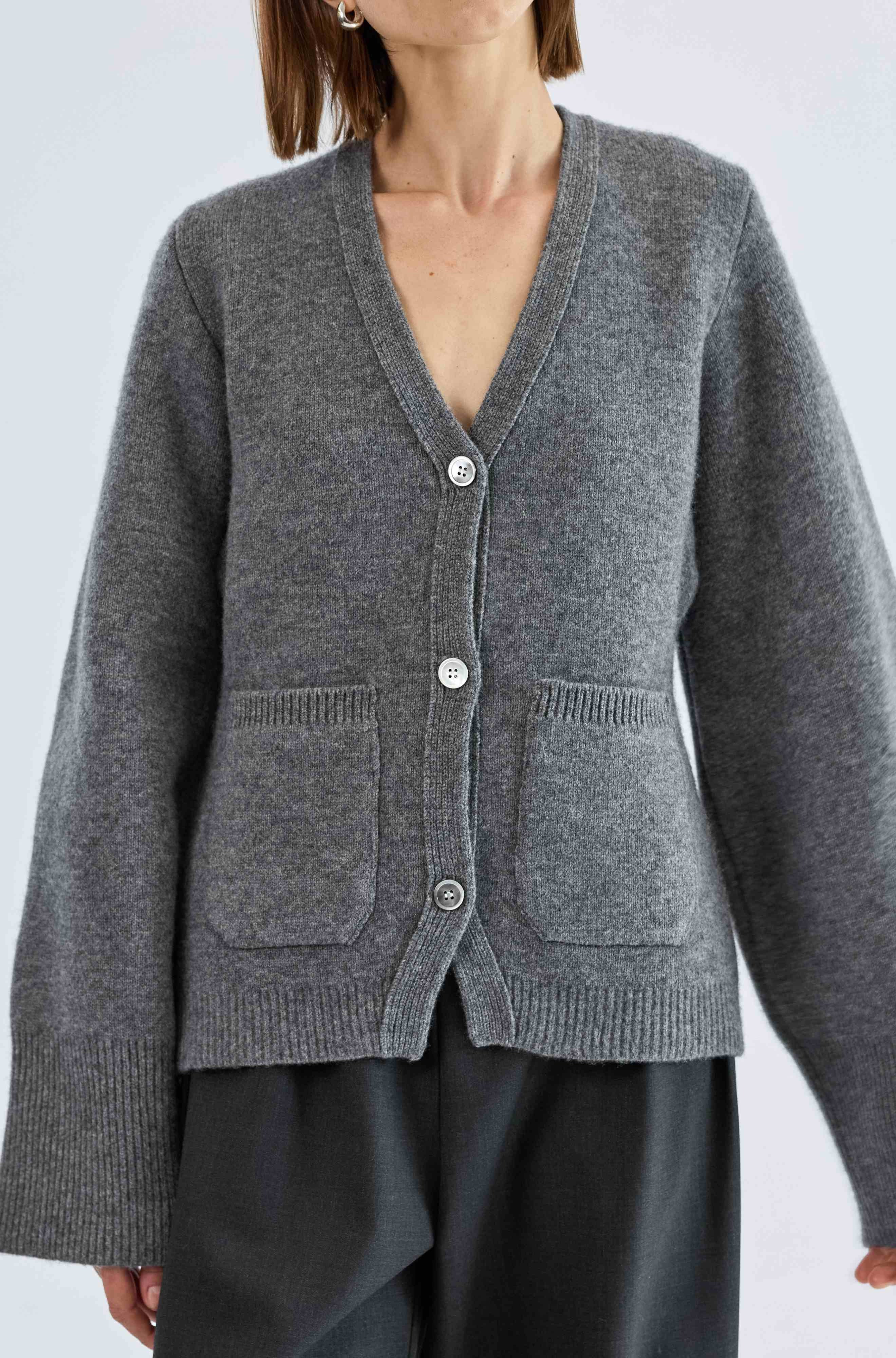 Gray cardigan worn by a person on a light gray background