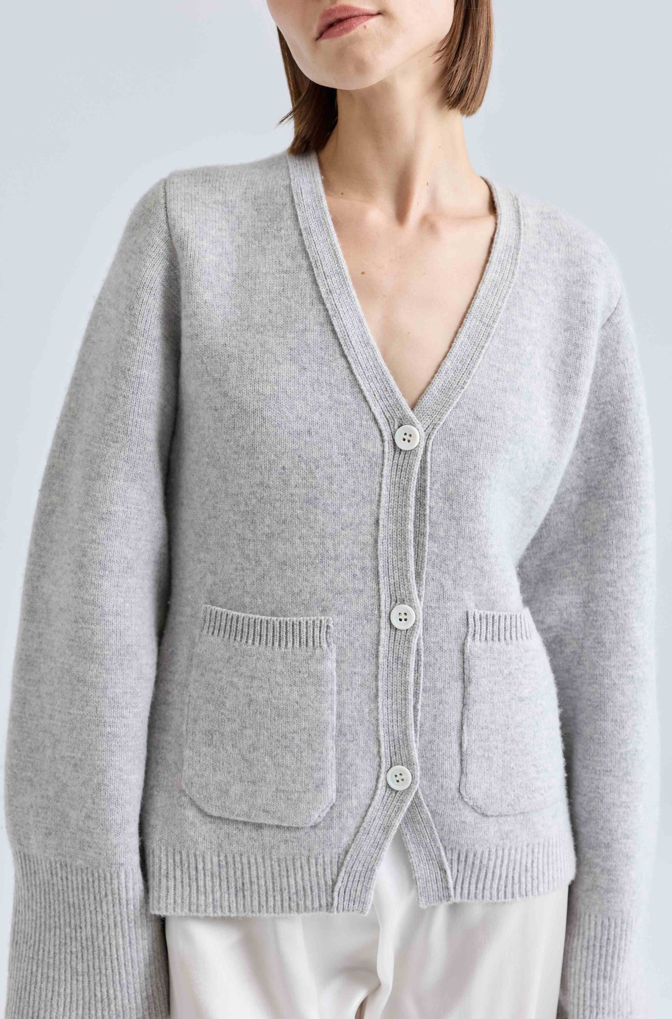 Gray cardigan worn by a person on a light gray background