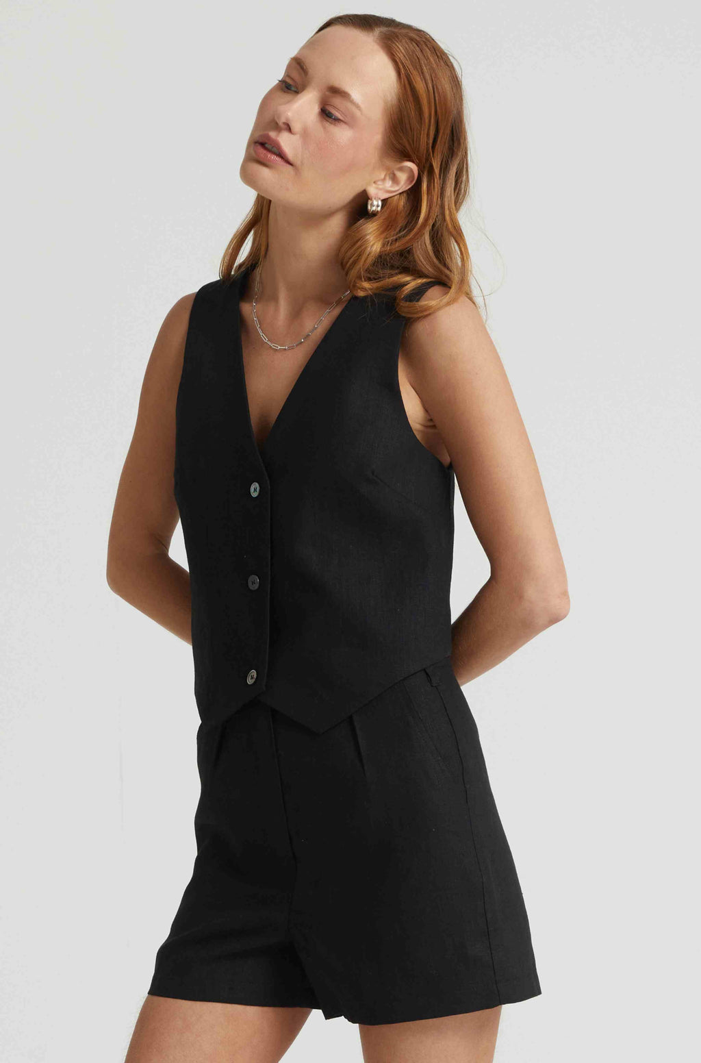 Woman wearing a black linen vest paired with black linen shorts
