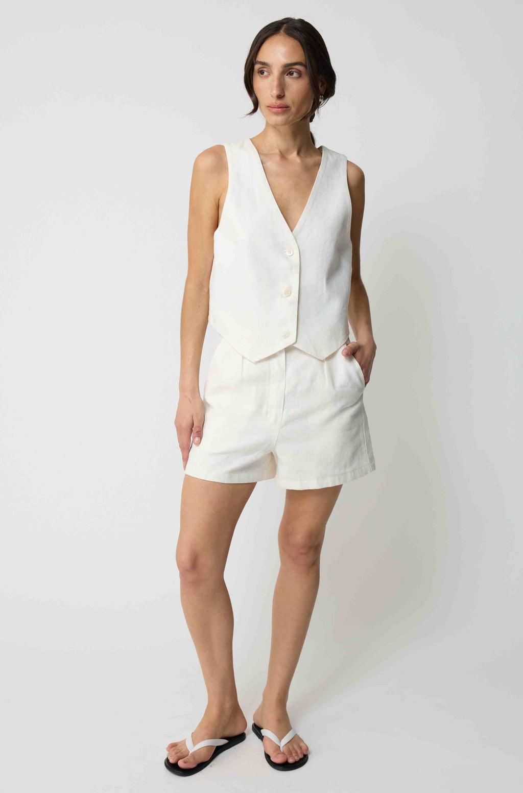 Woman wearing a white linen vest with matching white linen shorts