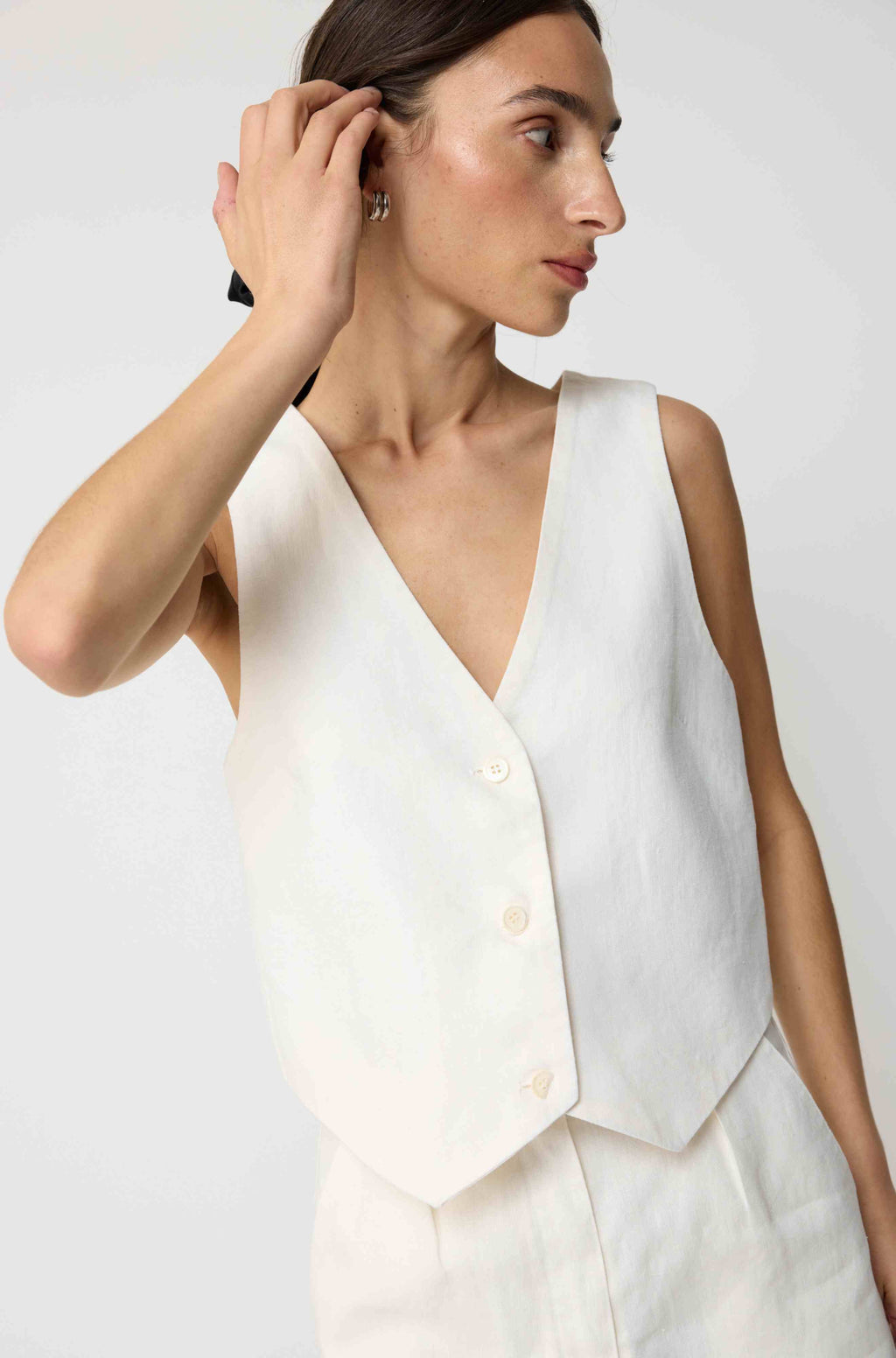 Woman wearing a white linen vest with matching white linen shorts