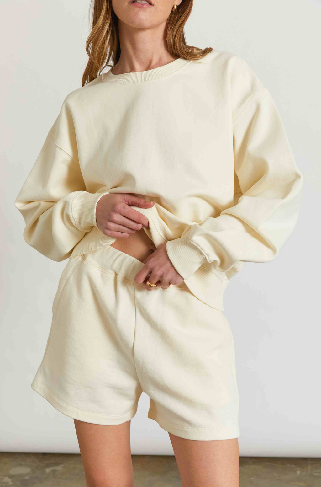 Woman wearing a yellow sweatshirt and matching sweatshorts