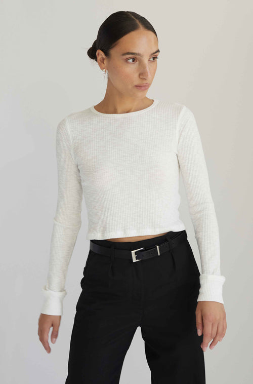 Woman wearing a white long sleeve top with black pants