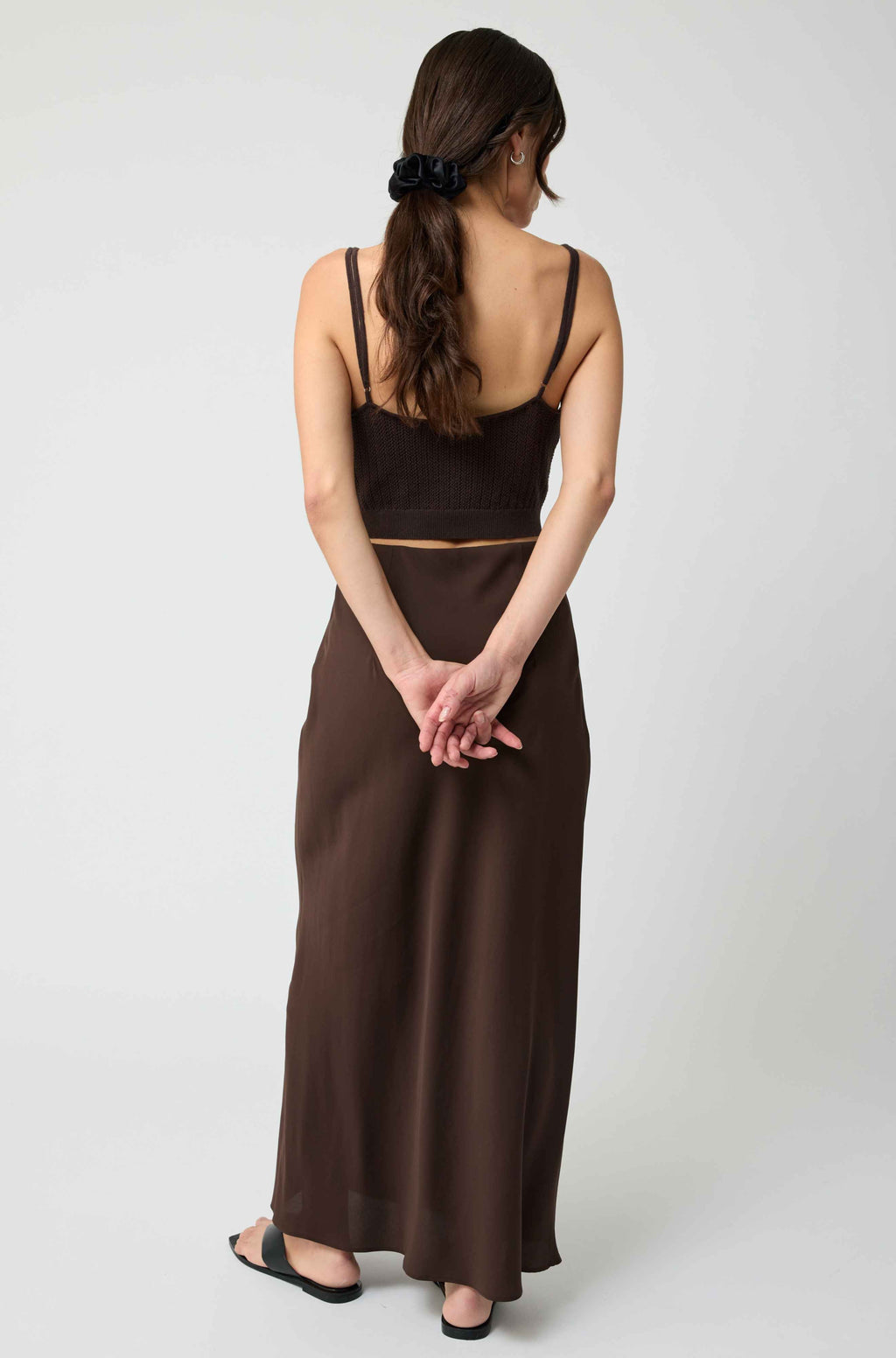 Woman wearing a brown dress with a plain white background