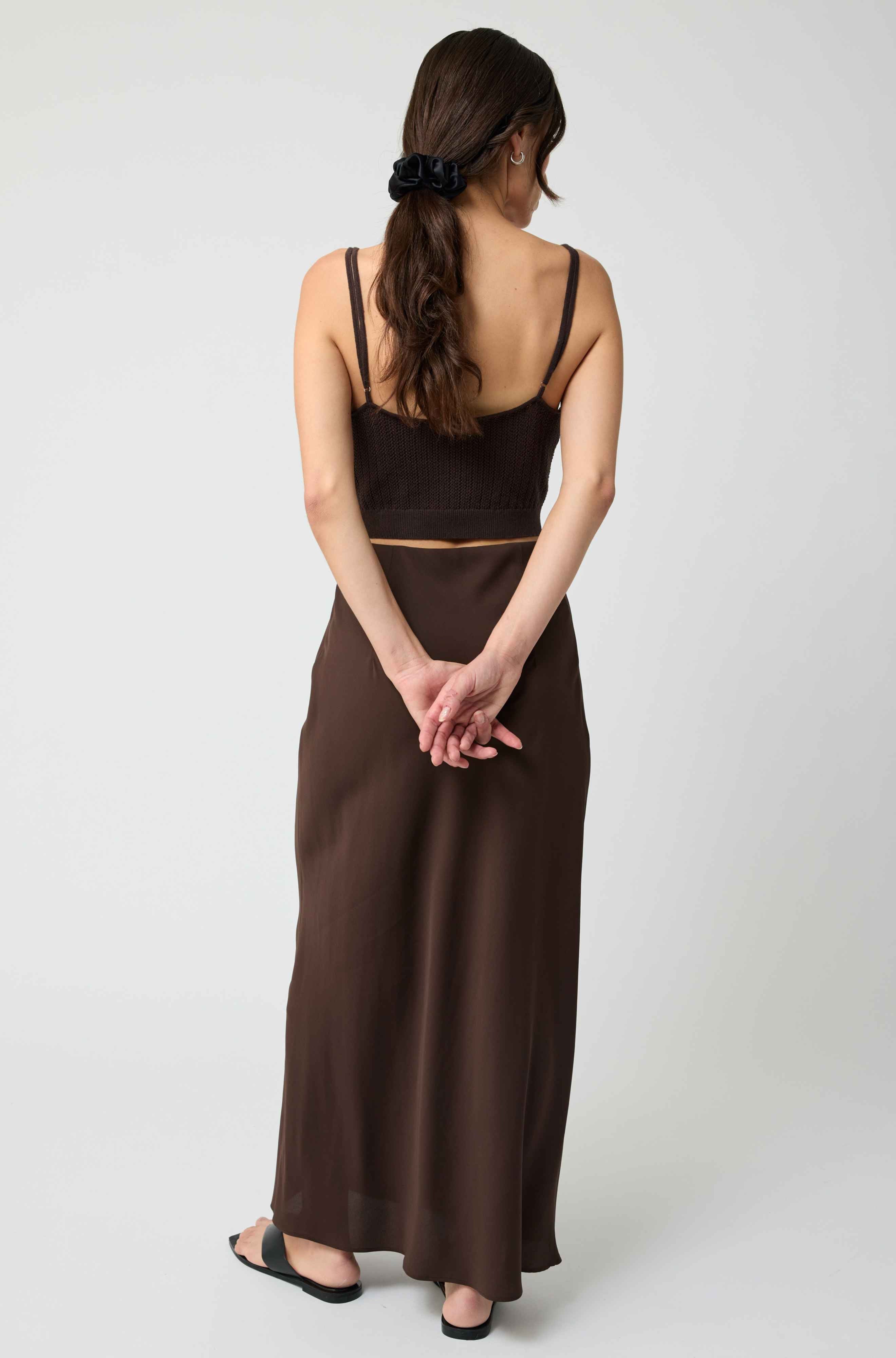 Woman wearing a brown dress with a plain white background