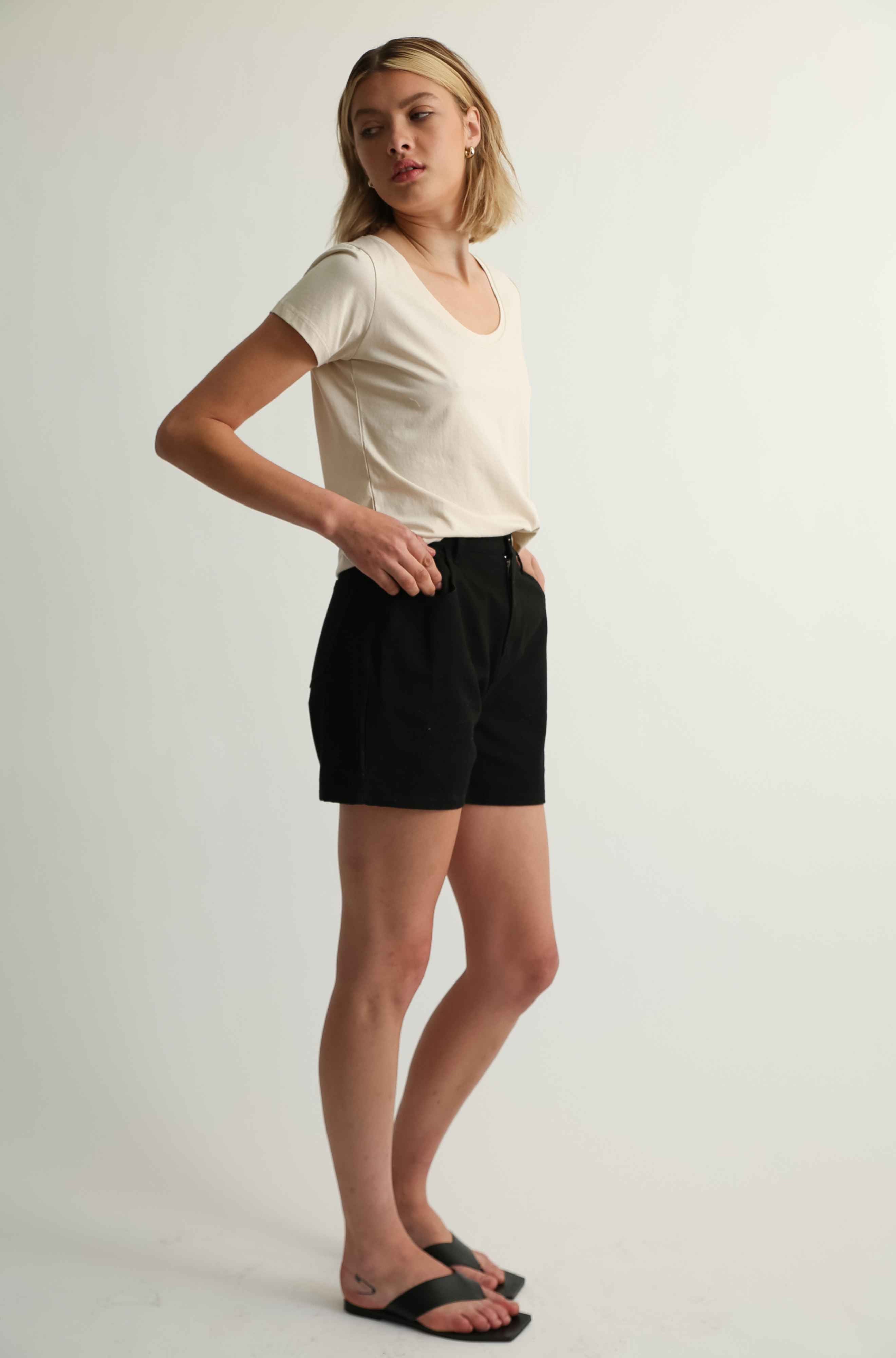 Woman wearing a beige tee and black shorts