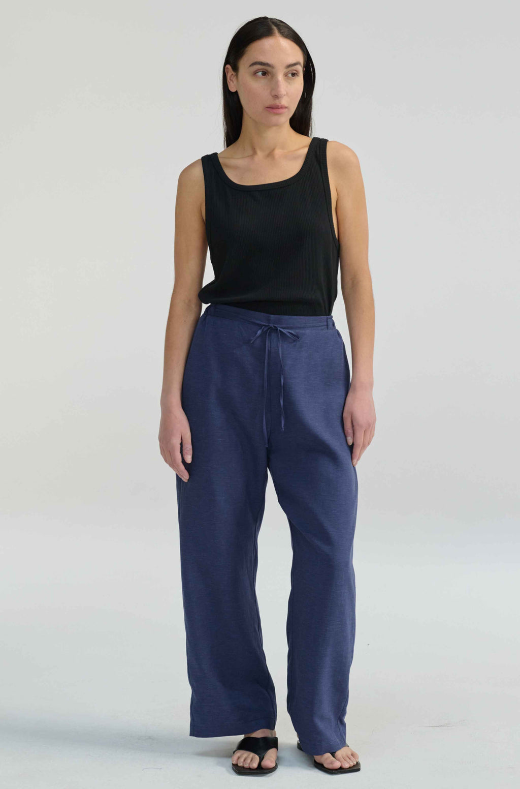 Woman wearing blue linen pants with a tie waist