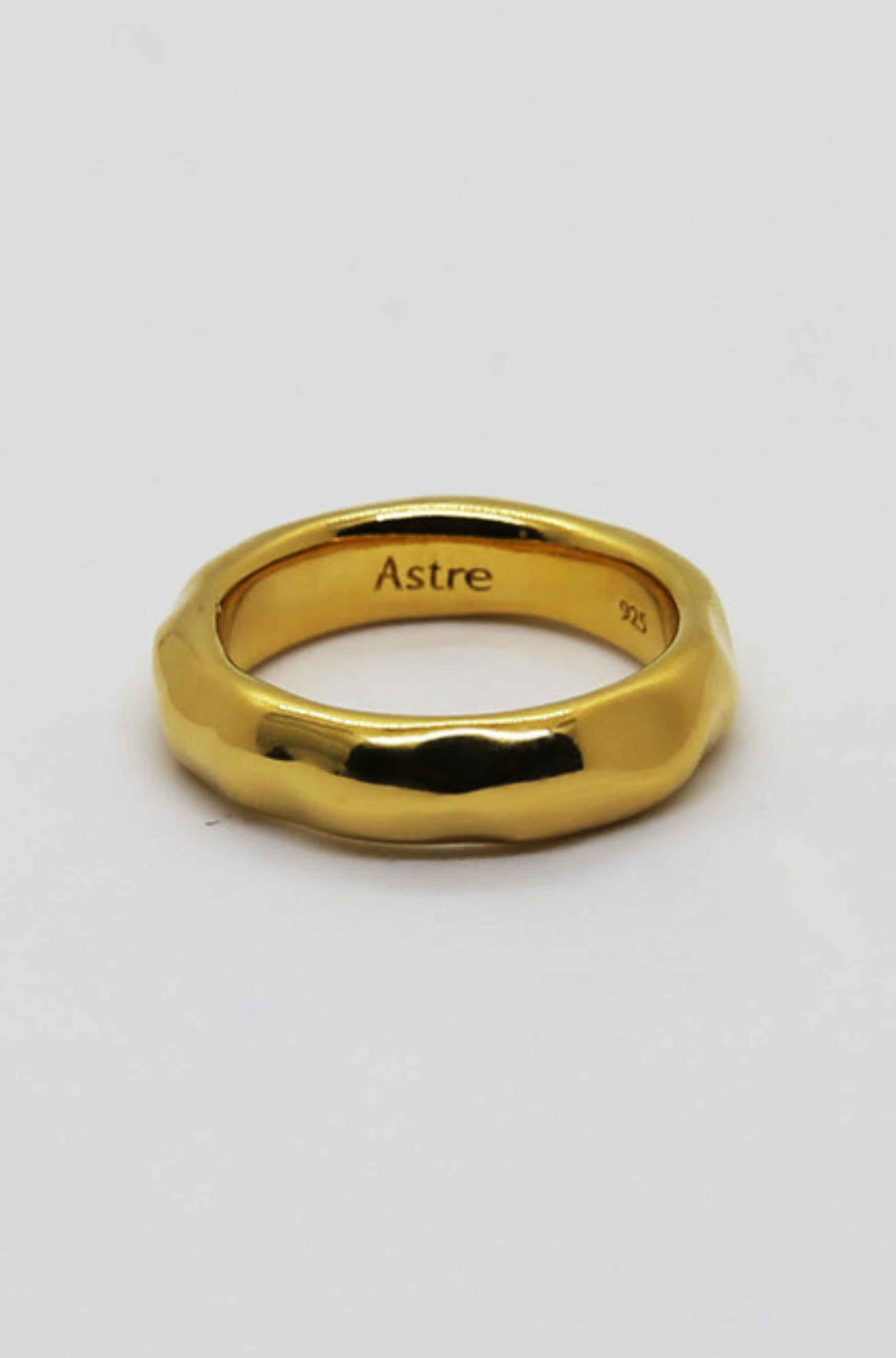 Gold ring against a light grey background