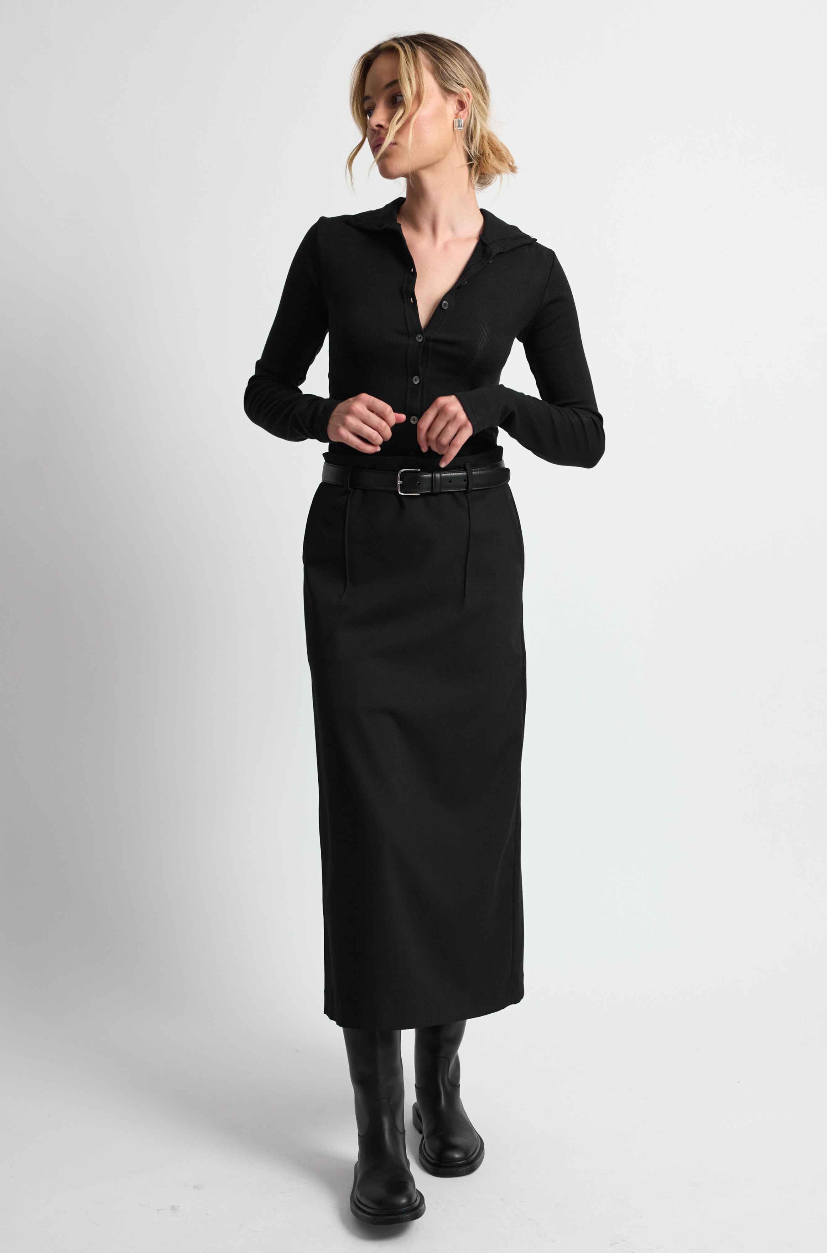 Woman wearing a black outfit on a light grey background