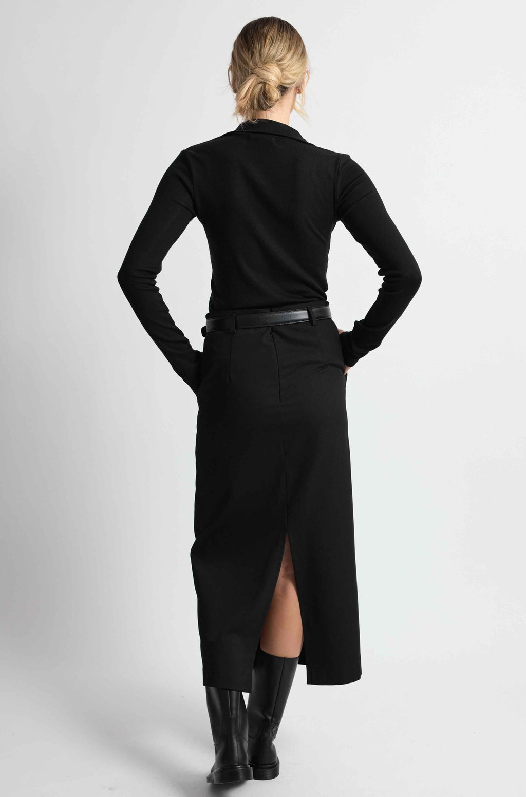 Woman wearing a black outfit on a light grey background
