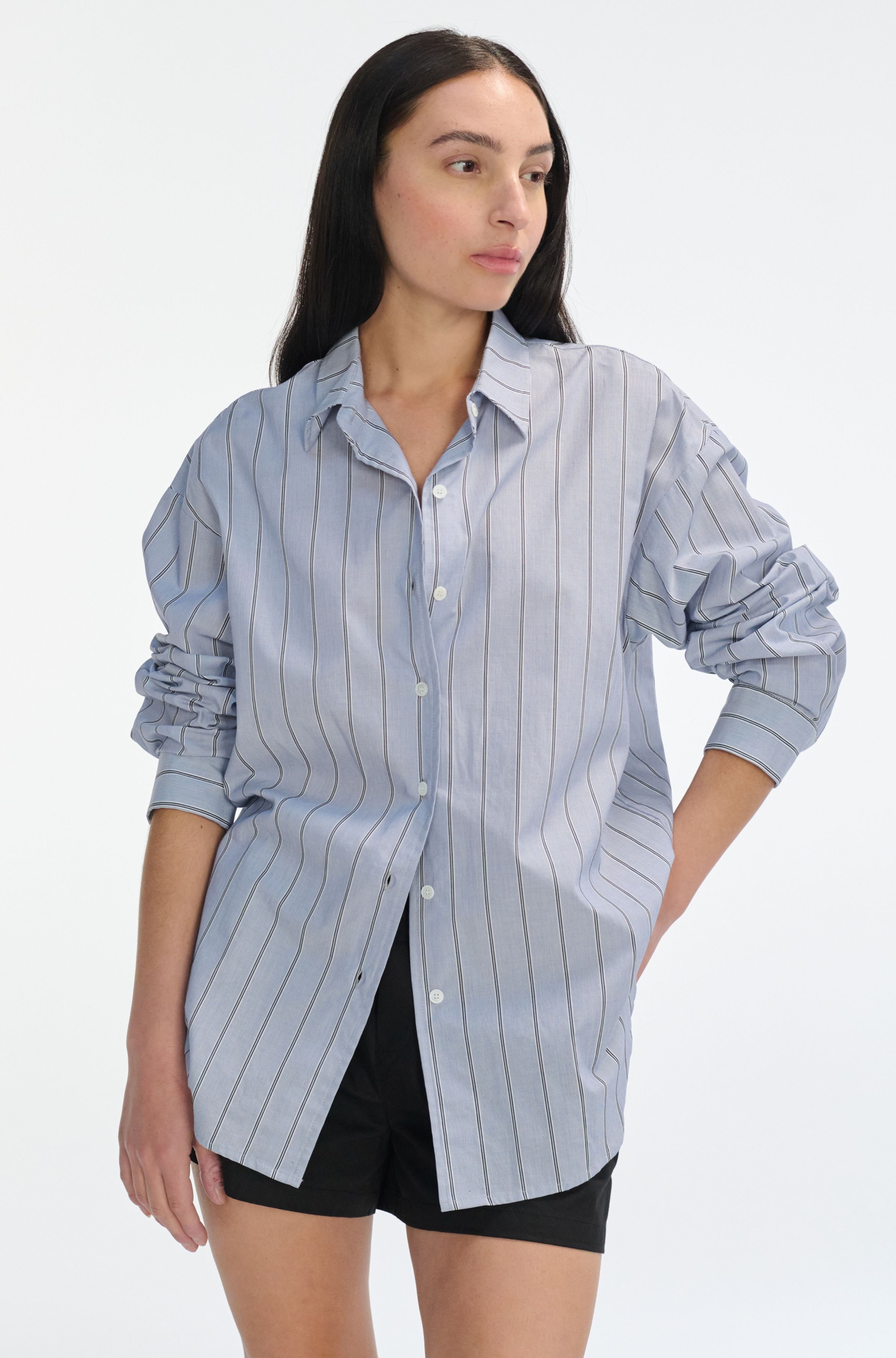 Woman wearing a light blue striped shirt on a white background