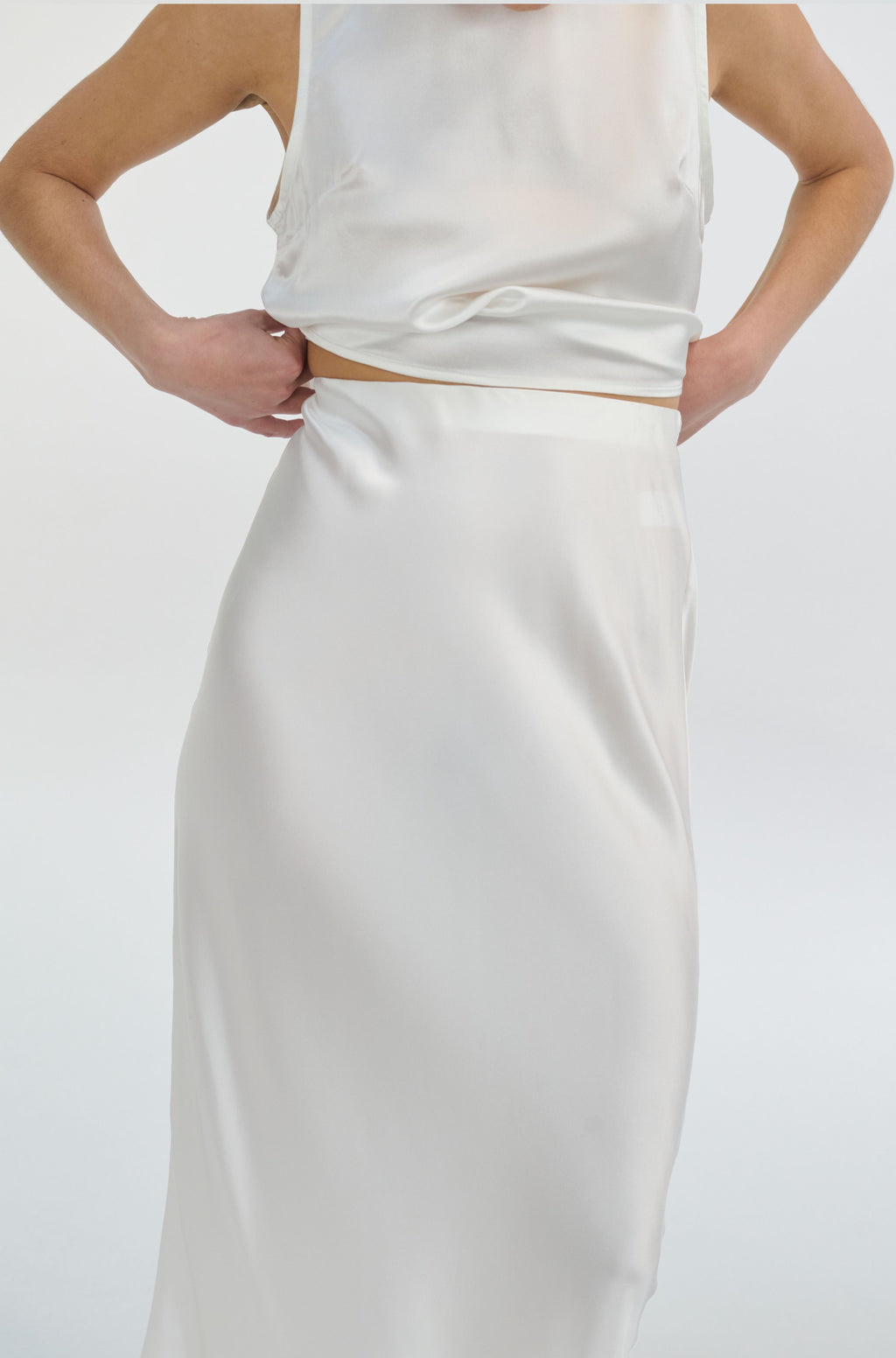 White silk skirt and top set on a plain background