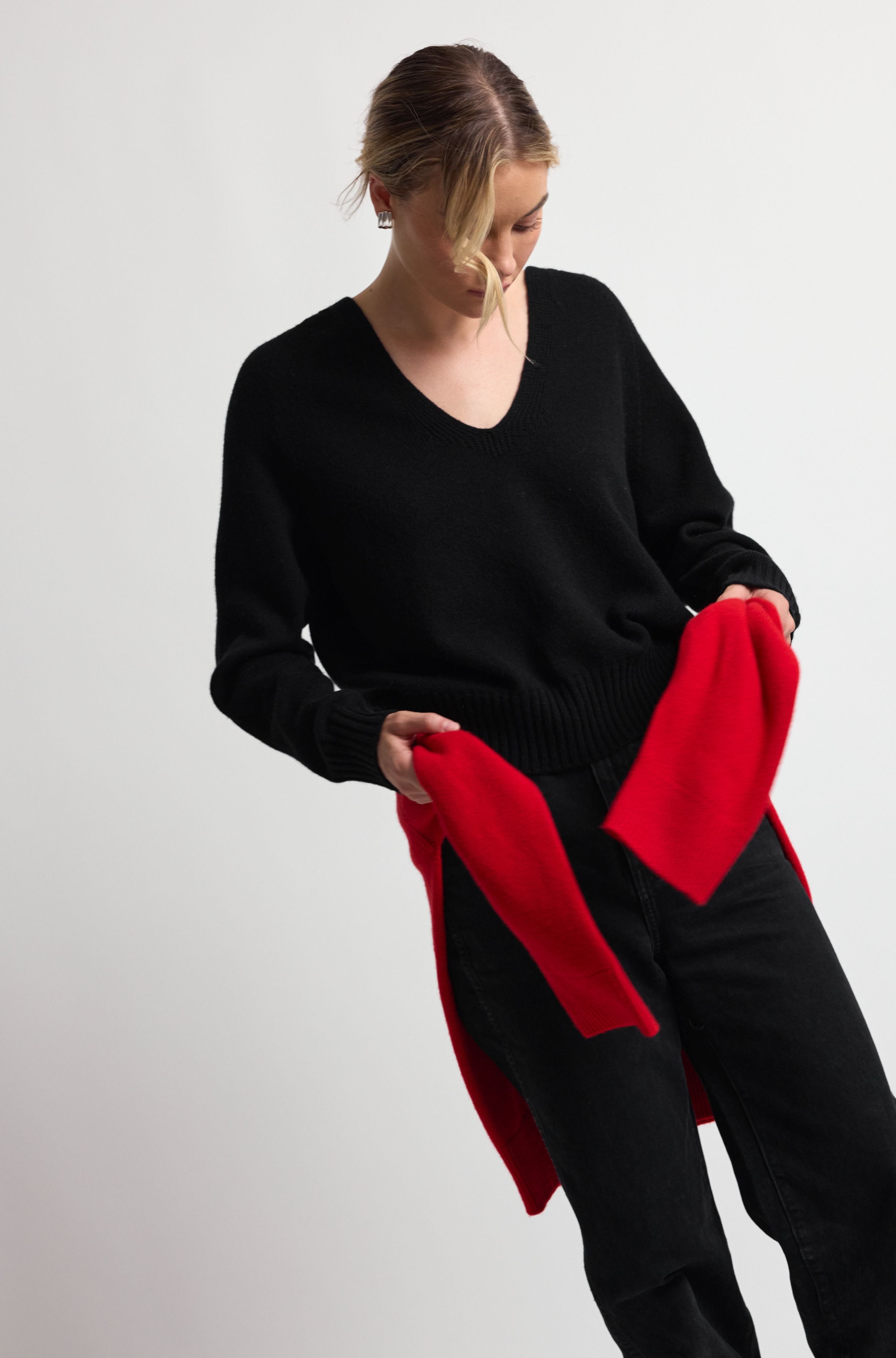 Woman holding a red garment against a plain background