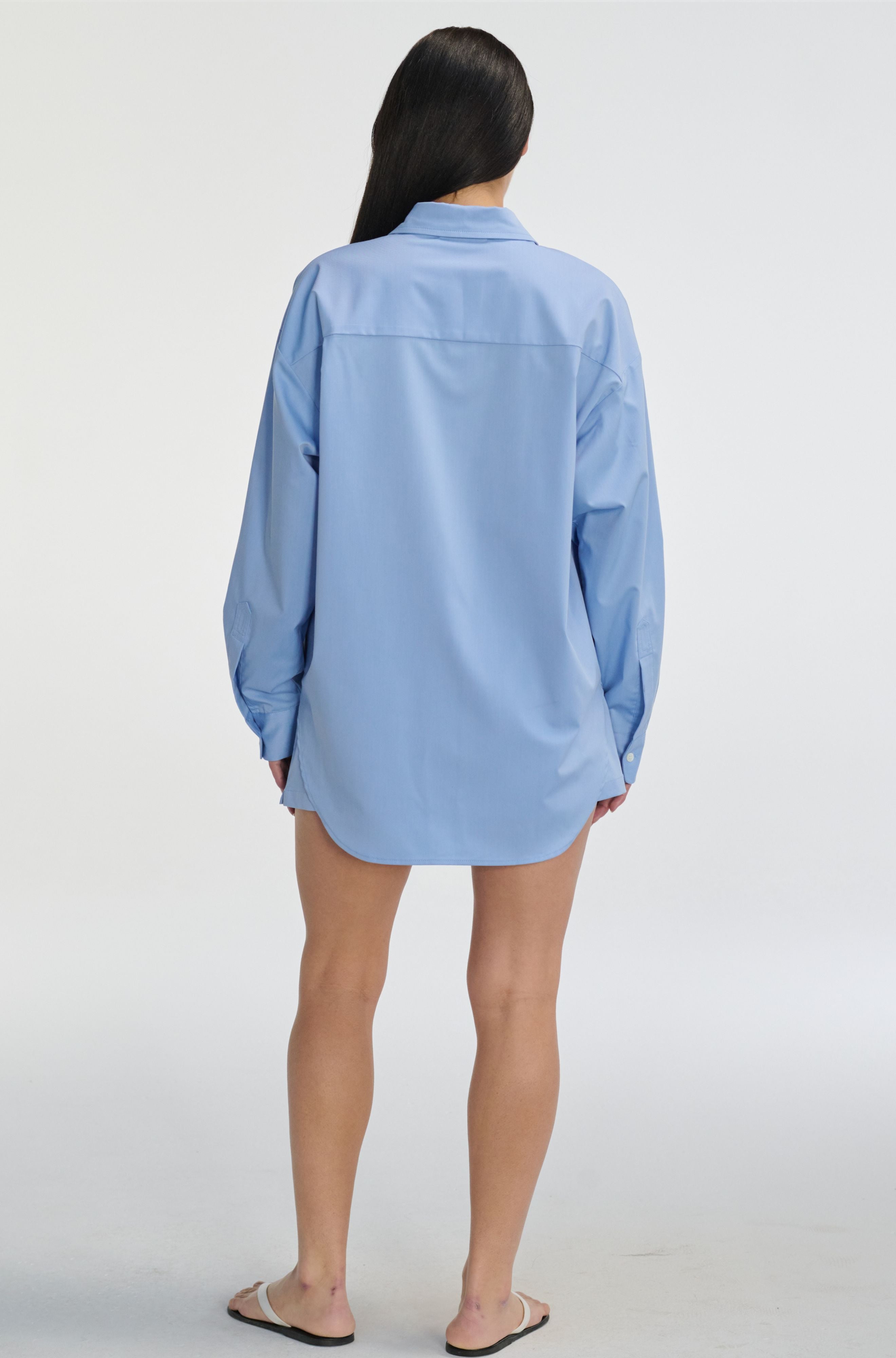 Person wearing a light blue shirt on a white background