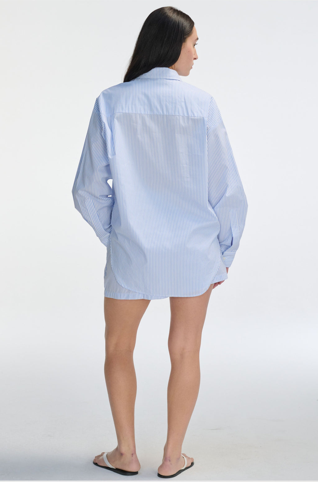 Person wearing a light blue checkered shirt on a white background