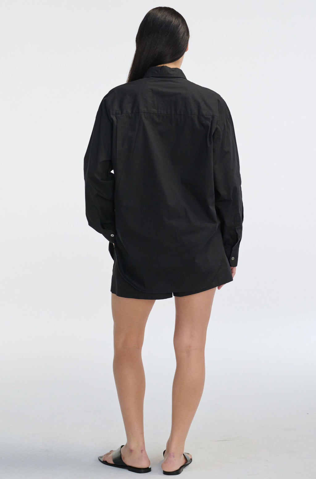 Person wearing a black shirt and shorts on a white background