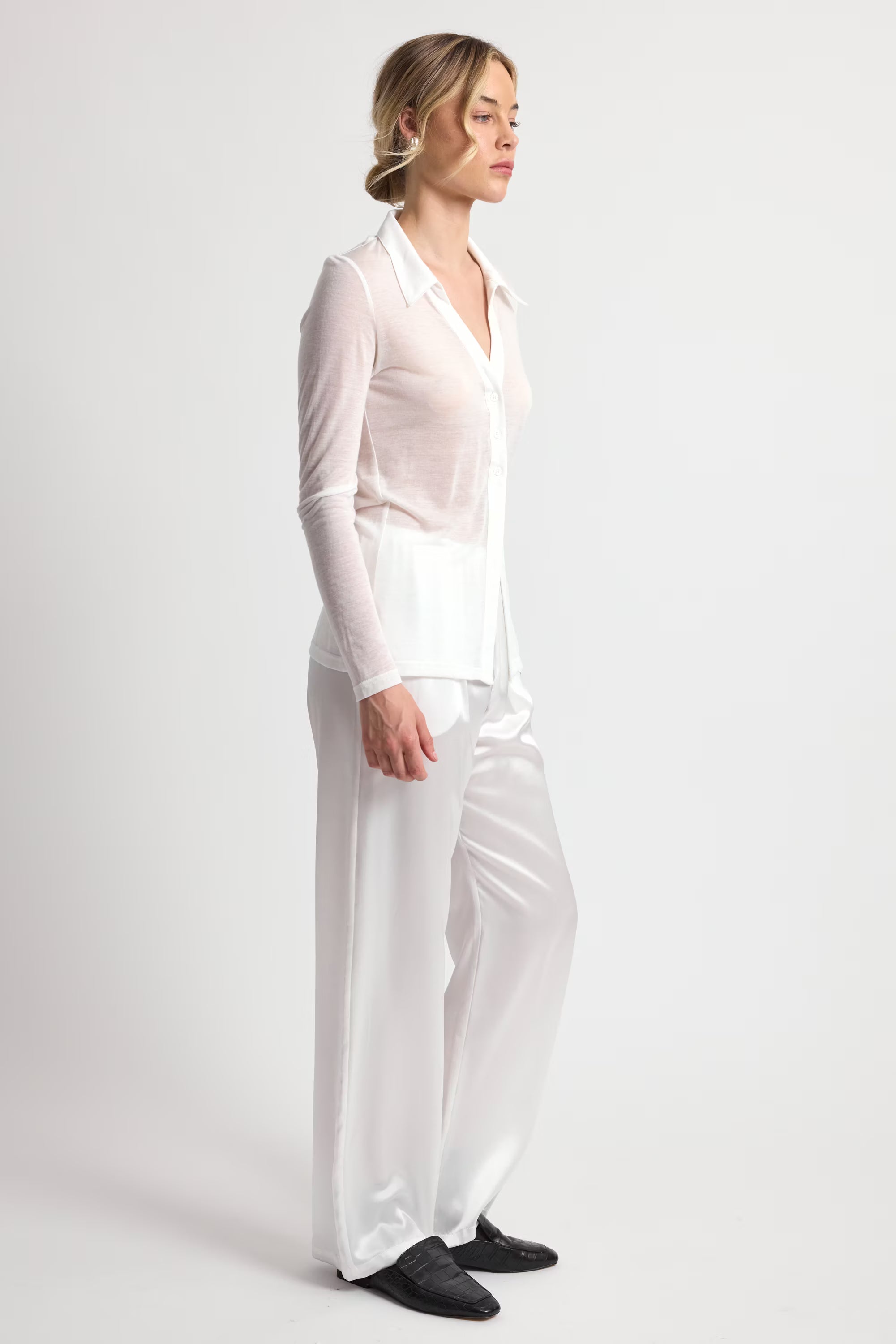 Woman wearing a white outfit on a plain background