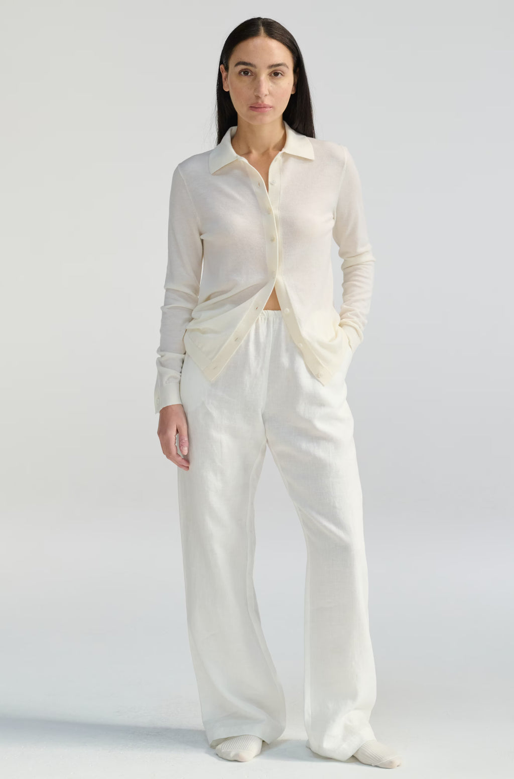 Woman wearing a white outfit on a plain background