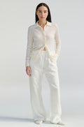 Woman wearing a white outfit on a plain background
