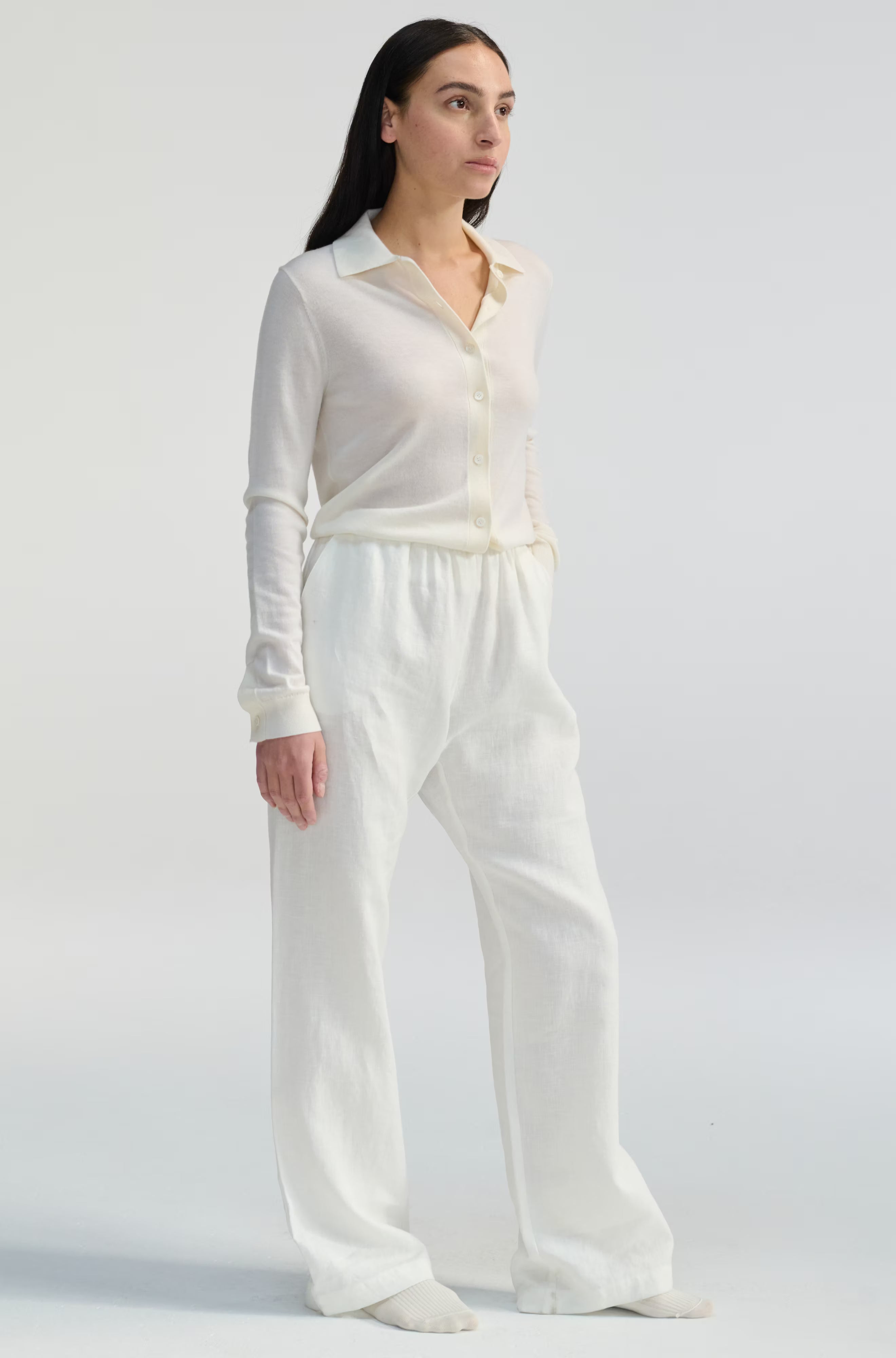 Woman wearing a white outfit on a plain background