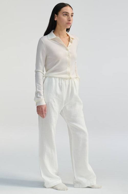 Woman wearing a white outfit on a plain background