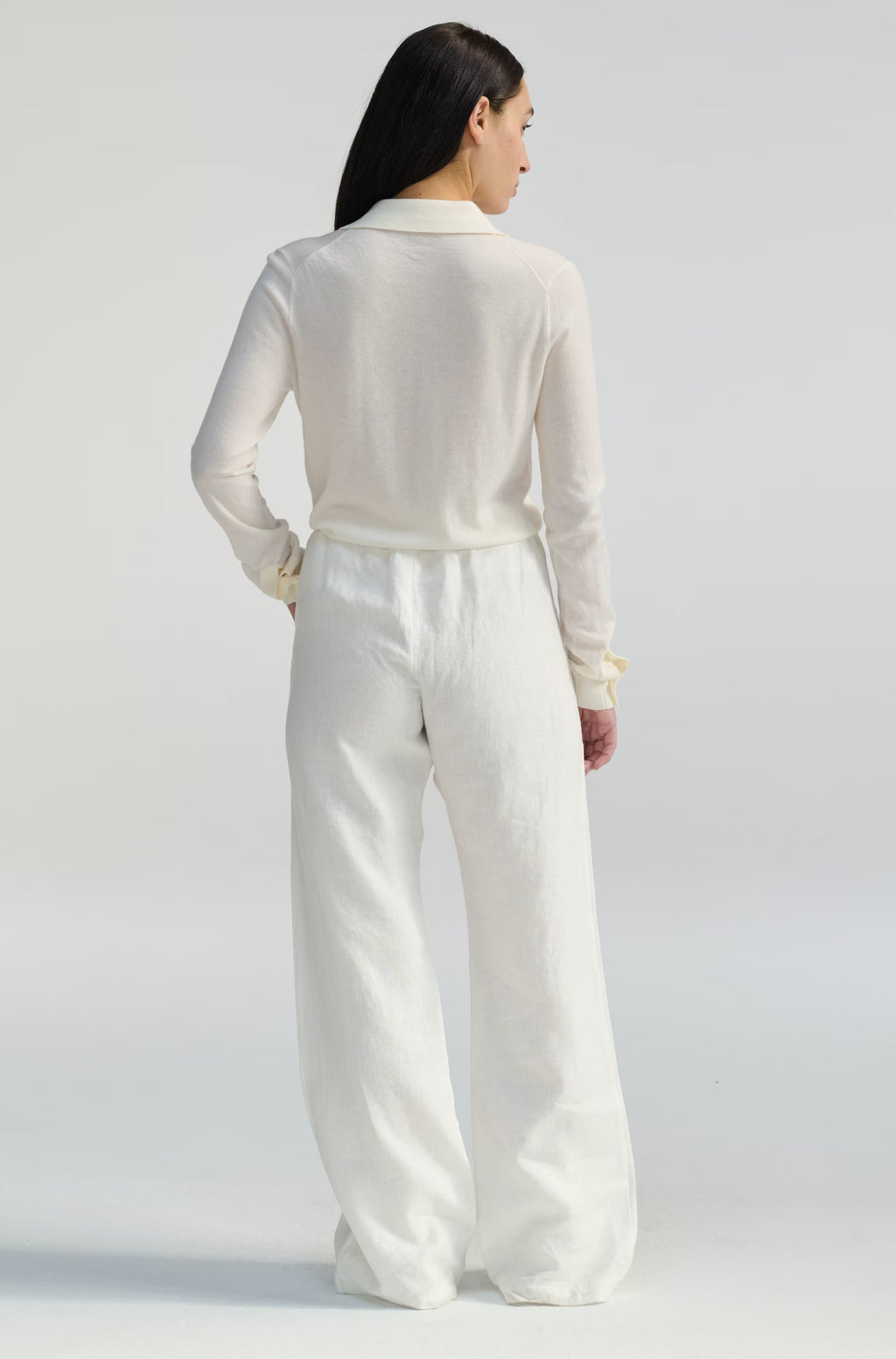 Person wearing a white outfit on a plain background