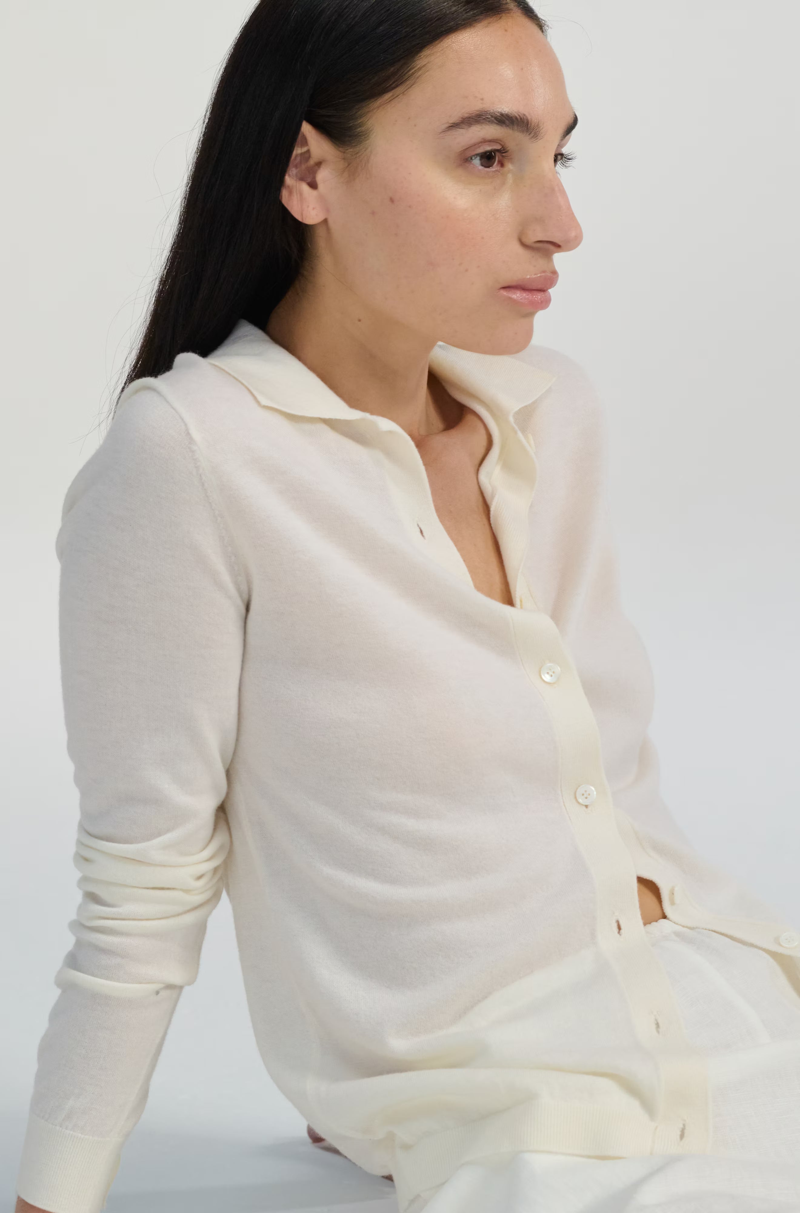 Woman wearing a white blouse against a plain background